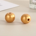 Macro shot of 16mm polished gold wooden beads with smooth finish and central drill holes - Gold