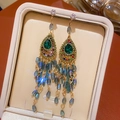 Close-up of Bohemian earrings with green teardrop stones and colorful bead tassels - No.43 Silver Earring Post - Green Rhinestone Teardrop Tassel Studs