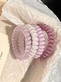 Detail of five elastic spiral hair ties in pink and white speckled resin on paper - 1# Grape Coconut 4-Piece Set