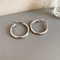 Close-up of polished silver hoop earrings on a textured display pad for daily wear - Silver Smooth Polished (4cm)