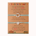 Dettaglio di due braccialetti intrecciati azzurri con cuore su una card per la scuola - Blu