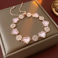 Detalle de una pulsera oro rosa con corazón de concha y motivos de sol en caja de joyería - Oro rosa