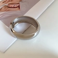 Detailansicht eines breiten silbernen Armreifs mit Hochglanzpolierung auf Modemagazin - Silber - Glänzend