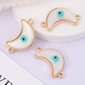 Macro shot of three white crescent evil eye connectors with gold trim for DIY jewelry - Moon