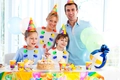 Familie trägt leuchtende LED-Halsketten auf einer bunten Geburtstagsparty mit Deko - Halbkugel Halbe Birne 9-LED Halskette
