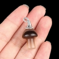 Brown semi-precious agate mushroom pendant with silver metal cap held on fingers - Gun Black Cap / Grey Agate