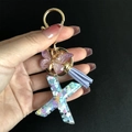 Close-up of letter X resin keychain with purple tassel and gold butterfly charm - Letter X / Butterfly Tassel 8-Shape Buckle
