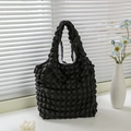 Macro detail of black bubble textured waffle fabric tote bag in minimalist home setting - Black