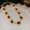 Detailansicht der Vintage-Goldhalskette mit bernsteinfarbenen Steinen und weißen Blumen - Halskette-Gold-Rot