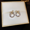 Détail macro de boucles d'oreilles nœud doré avec cristaux violets et perles - Style de couronne de noeud de strass pourpre (45#)