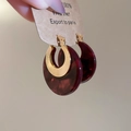 Close-up of vintage acetate round earrings with gold metal texture and red resin detail - Red
