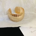 Primo piano del bracciale rigido dorato irregolare con trama a pieghe verticali - Stile 18 - Oro