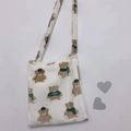 Detail view of plush brown bear pattern and soft faux fur texture on a cream tote bag - Off White