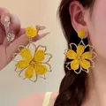 Pendientes largos de flores tejidas amarillo brillante estilo bohemio en una modelo - Flor con Marco de Metal y Centro Tejido / 5# Silver Earring Post - Dorado - Amarillo