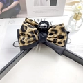 Elegant leopard print bow claw clip hair accessory for women styled on a fashion magazine - Dark Leopard Print