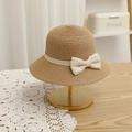 Close-up of straw sun hat with polka dot ribbon and lace trim on elegant display - Khaki Hat