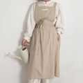 Beige cotton blend apron with square neck and wide straps in a minimal lifestyle view - Oatmeal
