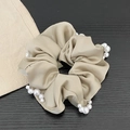 Elegant champagne satin scrunchie with pearl trim details on a dark wood background - Pearl Style / Champagne