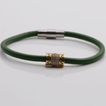 Dettaglio del bracciale in pelle verde con perla dorata traforata e chiusura magnetica - Verde Scuro/Oro