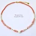 Dettaglio collana con perline arancioni, rosa e bianche su sfondo bianco, peso 10,6g - Stile Misto Perline Rosa Arancio (XB2404004-3)