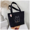 Dettaglio della borsa tote in velluto nero con ricamo di coniglio e ciondolo mucca - Borsa Singola / Nero