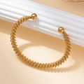 Detail van een gouden titanium stalen armband met gedraaid draad en bolvormige uiteinden - 8cm / Goud #5