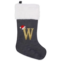 Detail of grey velvet Christmas stocking with embroidered gold letter W and a red Santa hat - Letter W