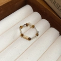 Vista macro de cuentas de ojo de tigre y tubos de plata en un anillo vintage étnico - 28# Anillo de Cuentas de Tubo Plateado y Ojo de Tigre