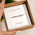 Gros plan du bracelet améthyste de février dans sa boîte cadeau en carton kraft - Février-Améthyste (Coffret)