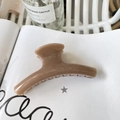 Close-up of a medium glossy brown hair claw clip on a white magazine with warm lighting - 11.5cm / Deep Nude Pink