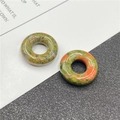 Macro detail of natural unakite stone beads in round donut shape with green and orange texture - Unakite