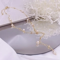 Detailed view of elegant gold pearl necklace with natural freshwater pearls on mirror surface - Y-shaped Tassel Style / White