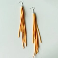 Detalle de pendientes bohemios de flecos largos naranjas con ganchos plateados - Amarillo