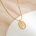 Detail of gold snake chain necklace with zircon oval frame and letter N pendant - Letter N