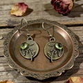 Pendientes vintage de flores en bronce con gema verde oliva sobre madera rústica - Girasol Bronce Gema Verde / Verde oliva