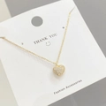 Dettaglio della collana a cuore dorato con cristalli micro-pave su un cartoncino bianco - Oro