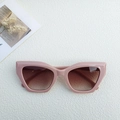 Pink cat-eye geometric sunglasses with brown gradient lenses on a textured surface - Rice Pink