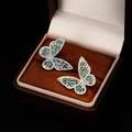 Detail of butterfly stud earrings with green step-cut gems and silver micro-pave setting - Silver Green