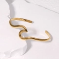 Bracciale rigido aperto in acciaio al titanio dorato con design geometrico su pietra bianca - Oro