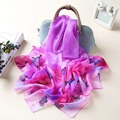 Elegant purple butterfly print silk scarf draped over a light blue handbag - Butterfly Purple