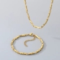 Dettaglio del set collana e bracciale a catena Chopin in acciaio dorato su sfondo grigio - Larghezza Catena 2.5mm/Bracciale 18cm / Oro