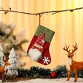 Close-up of burlap Christmas stocking featuring a gnome with snowflake patterns - Red