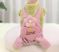 Detail eines Plüsch-Haustier-Overalls mit grünem Oberteil und rosa Cordhose mit Herz-Tasche - XS / Grüne Blume