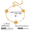 Makroansicht des goldenen Edelstahl-Gänseblümchen-Armbands mit orangefarbenem Zirkon - Blumenarmband (JDB0211101)