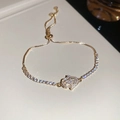 Detailed close-up of a golden Hamsa hand bracelet with zircon pavé and adjustable chain - Gold Hamsa Hand