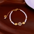 Elegant double-layer pearl bracelet with gold gourd zircon charms on brown satin fabric - Gold Hollow Pearl Bracelet (HB1506)