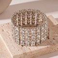 Dettaglio di un ampio bracciale elastico con file multiple di strass scintillanti - Stile Largo Diamante Rotondo Argento