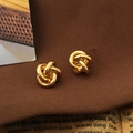 Detailansicht der goldenen Knoten-Ohrringe auf Vintage-Hintergrund mit edler Stoffstruktur - S925 Silber Nadel Paar / Gold