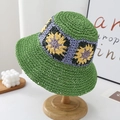Green crochet bucket hat with sunflower pattern on a wooden stand in home setting - One Size / Green