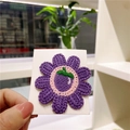 Purple knitted sunflower hair clip with pink center on white display card - Purple Flower With Eggplant